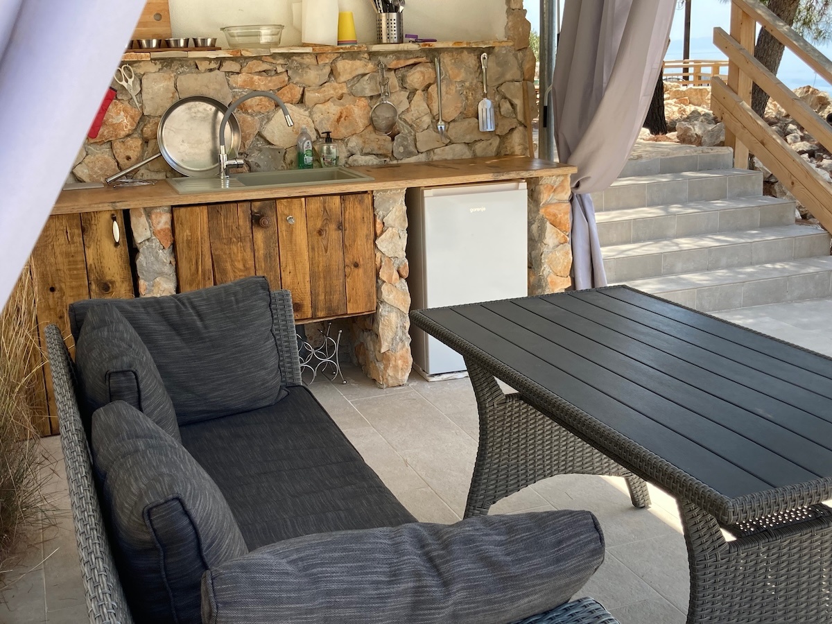 Outdoor kitchen on pool terrace with dining area